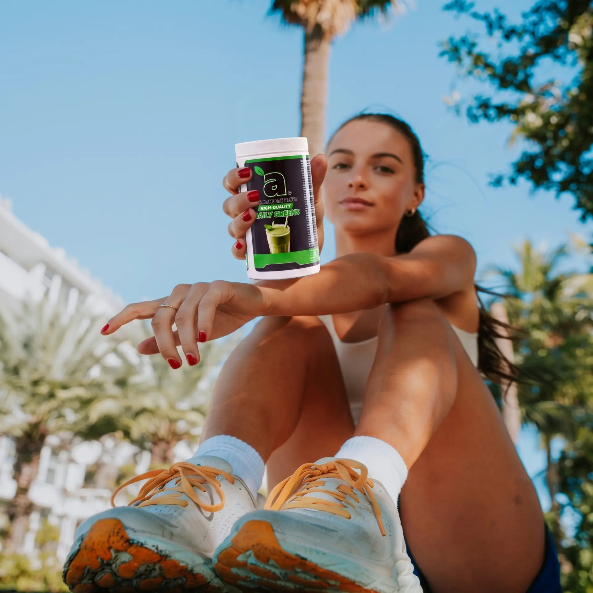 Athlete holding a tub of Athlete Reset Greens outdoors